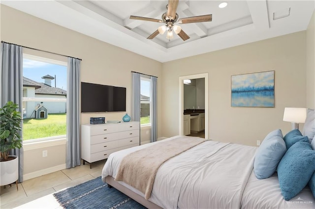 tiled bedroom with ceiling fan, a raised ceiling, coffered ceiling, and ensuite bath