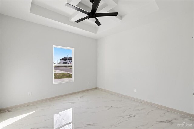 spare room featuring baseboards, a raised ceiling, marble finish floor, and a ceiling fan