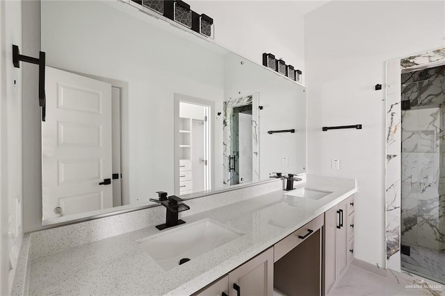 full bathroom featuring double vanity, marble finish floor, a marble finish shower, and a sink