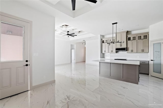 kitchen featuring marble finish floor, a ceiling fan, coffered ceiling, exhaust hood, and glass insert cabinets