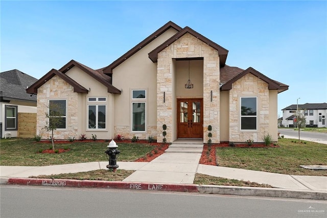 view of front of property featuring a front yard, french doors, and stucco siding