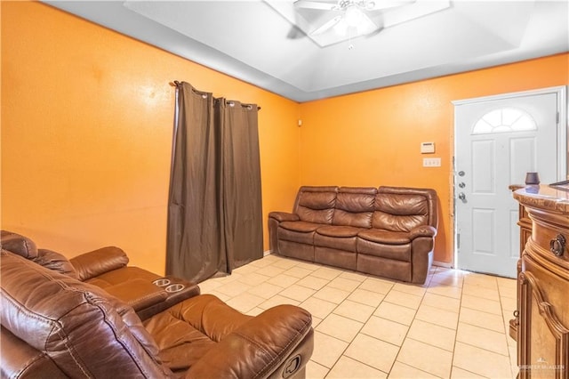 tiled living room with a tray ceiling and ceiling fan