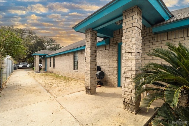 property exterior at dusk featuring a patio