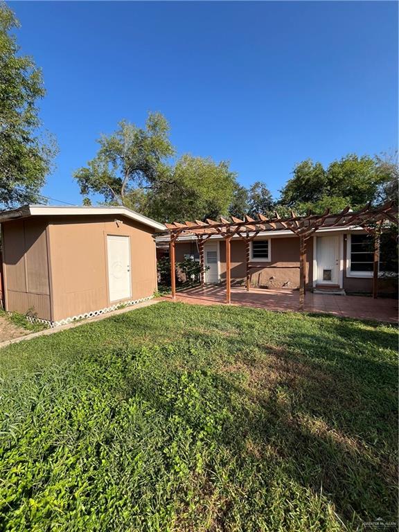 exterior space featuring a pergola, a front lawn, and a patio