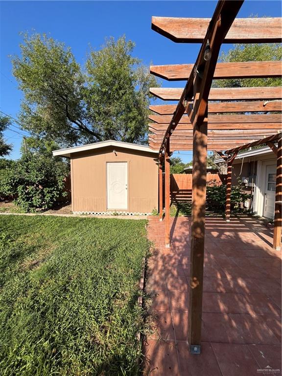 view of yard with a pergola, a patio, and a shed