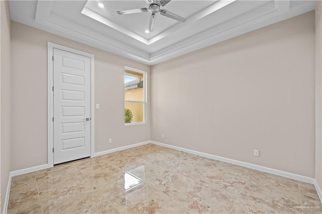 empty room with a tray ceiling and ceiling fan