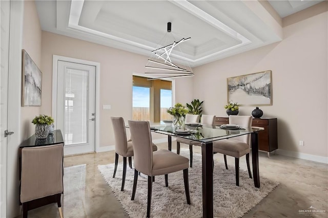 dining area featuring an inviting chandelier and a tray ceiling