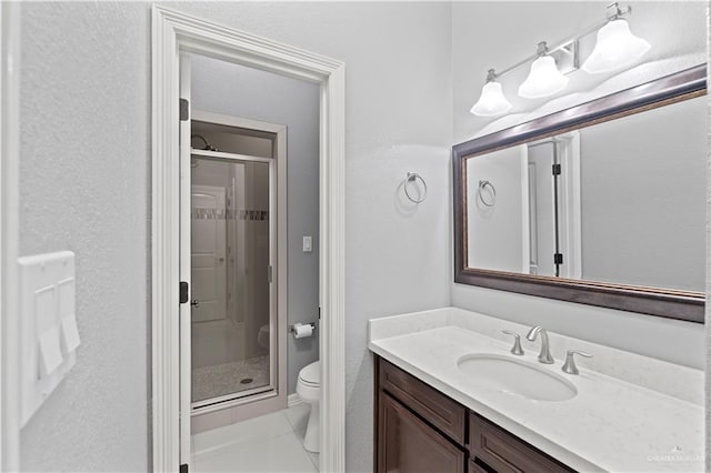 bathroom with vanity, tile patterned flooring, toilet, and walk in shower