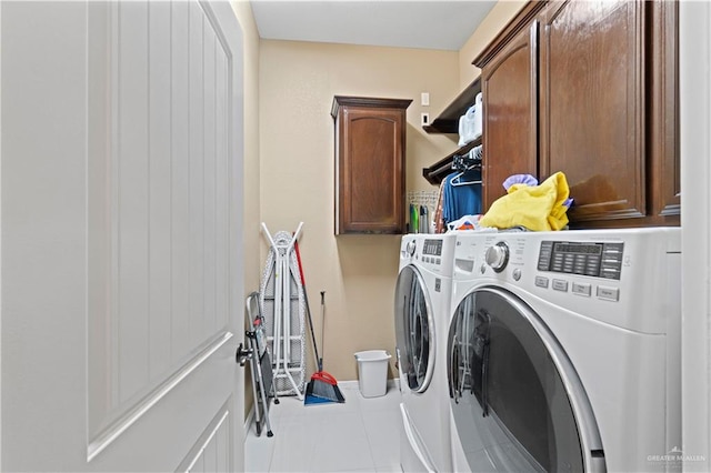 laundry room with cabinets, washer and clothes dryer, and tile patterned flooring