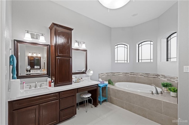 bathroom featuring a relaxing tiled tub, vanity, plenty of natural light, and tile patterned floors