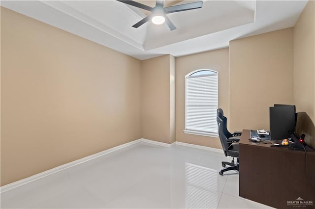 office featuring light tile patterned floors, a tray ceiling, and ceiling fan