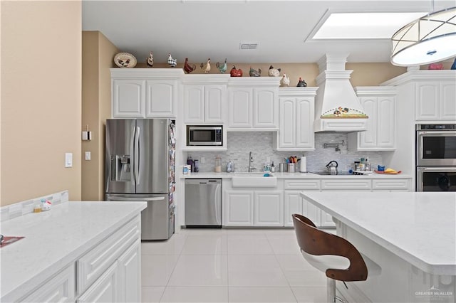 kitchen with white cabinetry, sink, decorative light fixtures, and stainless steel appliances