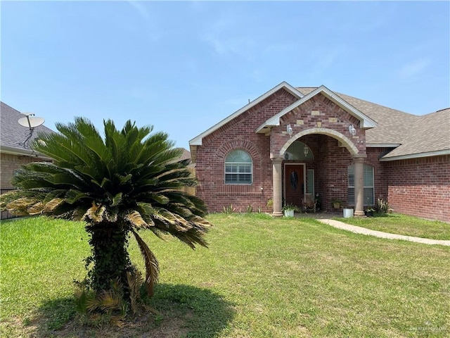 2500 W Xanthisma Ave, Mcallen, TX 78504 - view of front of home with brick siding, a front yard, and a shingled roof