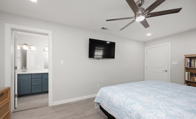 bedroom with ceiling fan, light hardwood / wood-style floors, sink, and ensuite bathroom