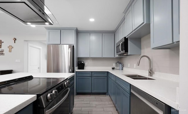 kitchen featuring backsplash, sink, range hood, and appliances with stainless steel finishes