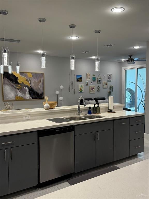 kitchen featuring dishwasher, light countertops, dark cabinetry, pendant lighting, and a sink