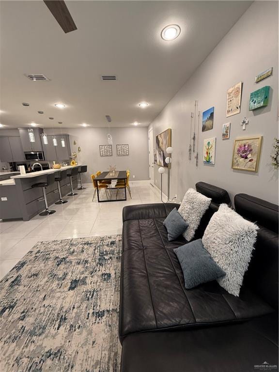 living area featuring light tile patterned flooring and visible vents