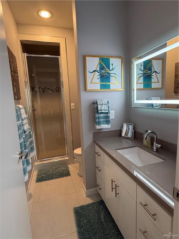 full bath with baseboards, toilet, tile patterned floors, vanity, and a shower stall