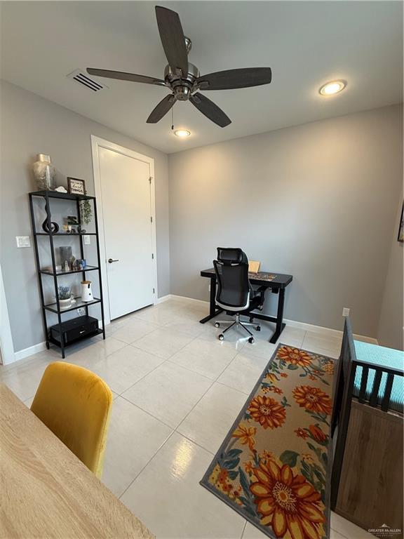 office featuring light tile patterned floors, a ceiling fan, visible vents, and baseboards