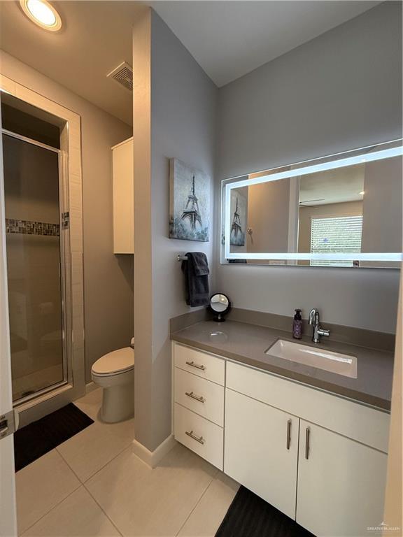 full bathroom with visible vents, toilet, a shower stall, vanity, and tile patterned floors