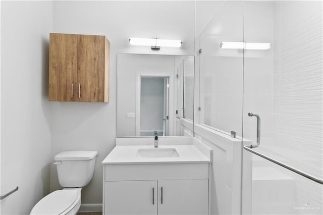 bathroom featuring vanity, toilet, and a shower with door