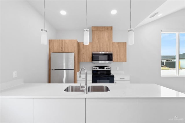 kitchen with white cabinetry, sink, hanging light fixtures, and appliances with stainless steel finishes