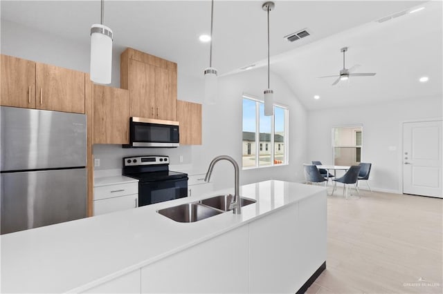 kitchen with sink, white cabinetry, light hardwood / wood-style flooring, pendant lighting, and stainless steel appliances