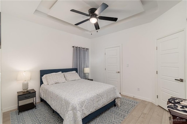 901 E Yuma Ave Unit 504, Mcallen, TX 78503 - bedroom with a raised ceiling, light wood-style floors, a ceiling fan, and baseboards
