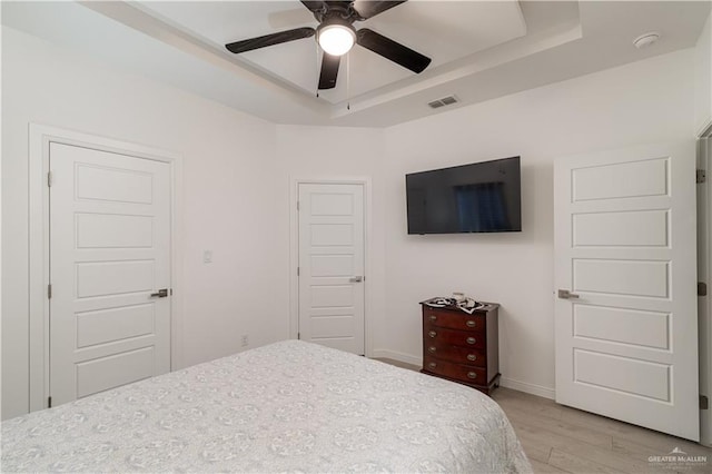 901 E Yuma Ave Unit 504, Mcallen, TX 78503 - bedroom featuring a raised ceiling, light wood-style floors, baseboards, and a ceiling fan