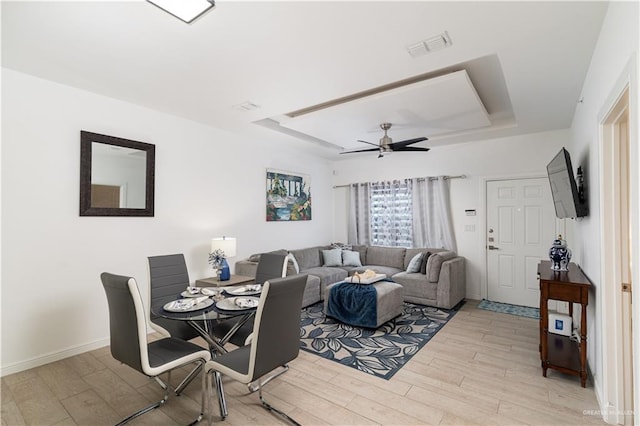 901 E Yuma Ave Unit 504, Mcallen, TX 78503 - living area featuring a tray ceiling, light wood finished floors, a ceiling fan, and baseboards
