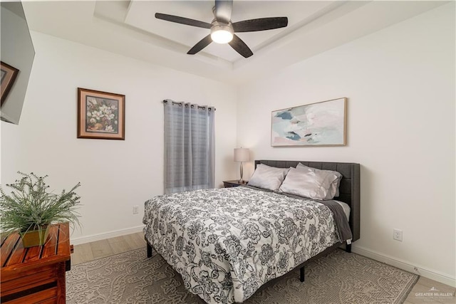 901 E Yuma Ave Unit 504, Mcallen, TX 78503 - bedroom with a raised ceiling, baseboards, light wood-style floors, and a ceiling fan