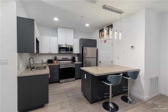 901 E Yuma Ave Unit 504, Mcallen, TX 78503 - kitchen featuring appliances with stainless steel finishes, a sink, light wood-style floors, decorative backsplash, and recessed lighting