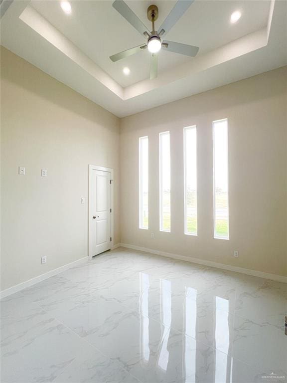 2309 S Cartier Dr, Edinburg, TX 78542 - empty room with a raised ceiling, recessed lighting, baseboards, light marble finish flooring, and ceiling fan