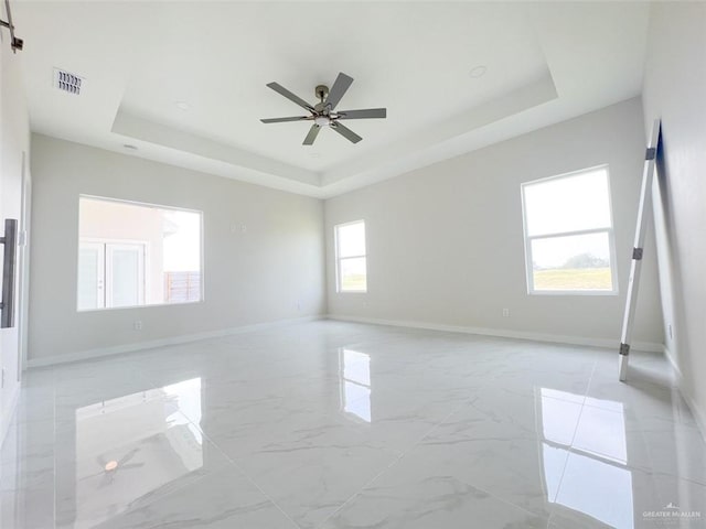 2309 S Cartier Dr, Edinburg, TX 78542 - empty room with a tray ceiling, ceiling fan, baseboards, and light marble finish flooring