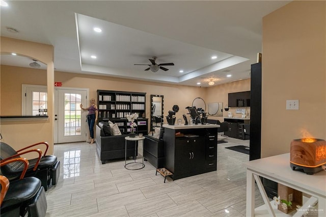 kitchen with a tray ceiling, ceiling fan, and a kitchen island