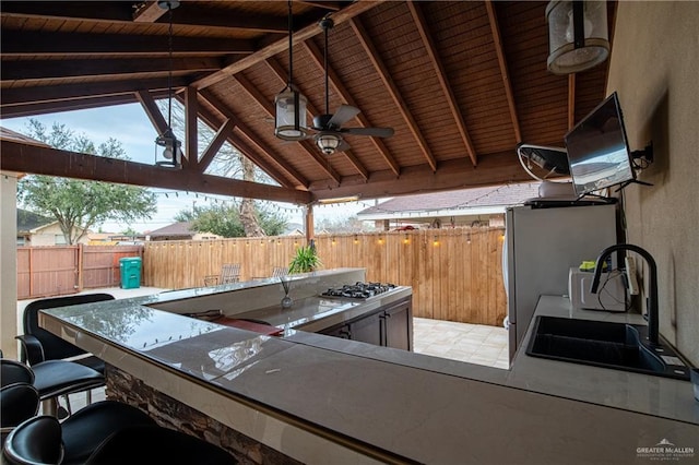 view of patio / terrace featuring a gazebo, ceiling fan, an outdoor kitchen, and an outdoor wet bar