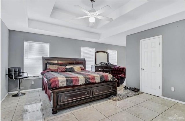 bedroom featuring multiple windows, light tile patterned floors, a raised ceiling, and ceiling fan