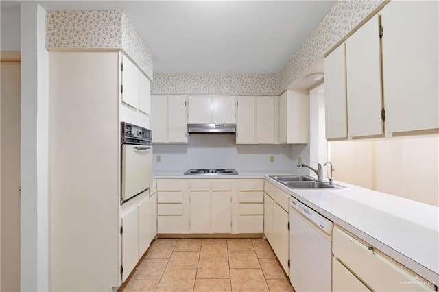 207 E Jackson Ave, Mcallen, TX 78501 - kitchen with white appliances, under cabinet range hood, light countertops, and light tile patterned floors