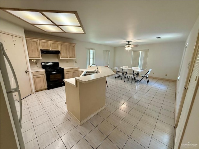 6501 Magnum Rd, Mission, TX 78573 - kitchen with black gas range oven, under cabinet range hood, light brown cabinets, light tile patterned floors, and ceiling fan