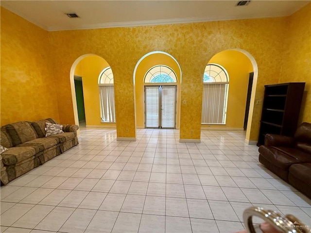6501 Magnum Rd, Mission, TX 78573 - unfurnished living room with arched walkways, light tile patterned flooring, a high ceiling, and crown molding
