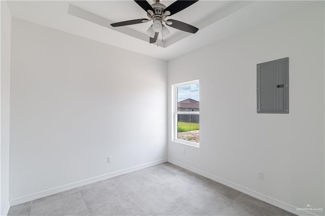 unfurnished room with electric panel, ceiling fan, and a tray ceiling