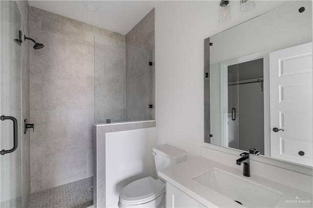 bathroom featuring vanity, toilet, and an enclosed shower