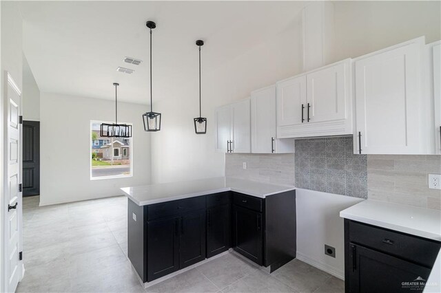 kitchen with white cabinets, decorative backsplash, decorative light fixtures, and kitchen peninsula