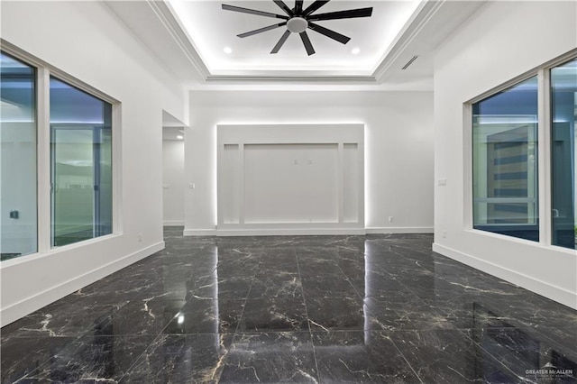 interior space featuring ceiling fan, a raised ceiling, and ornamental molding