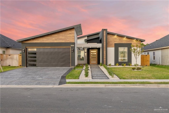 contemporary house featuring a lawn and a garage