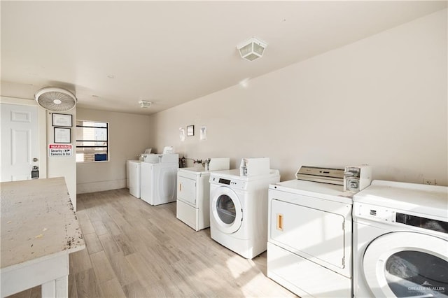 shared laundry area with washing machine and dryer and light wood-style flooring