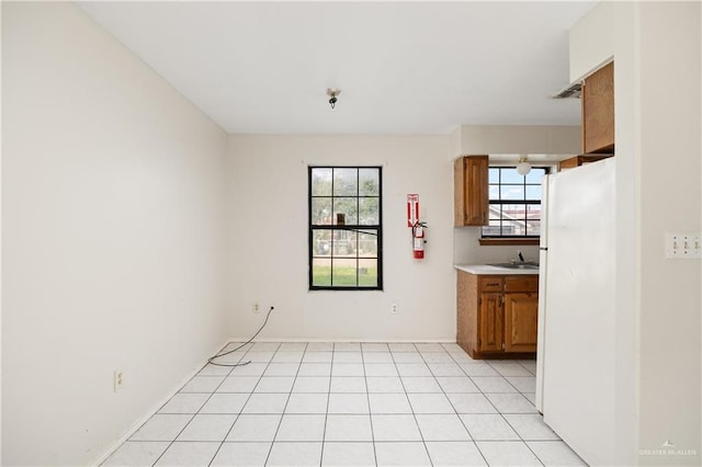 unfurnished dining area with light tile patterned flooring and a sink