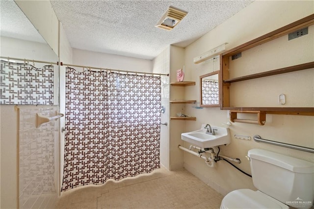 1215 Oak St, Mission, TX 78572 - full bathroom with toilet, a shower with shower curtain, a textured ceiling, and a sink