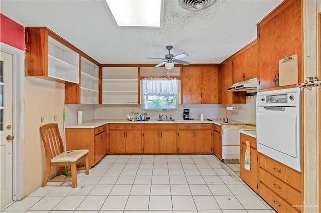 1215 Oak St, Mission, TX 78572 - kitchen with oven, under cabinet range hood, light countertops, ceiling fan, and a textured ceiling