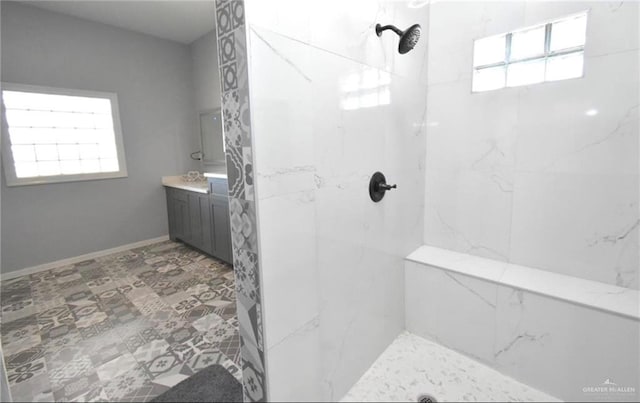 bathroom with tiled shower and vanity